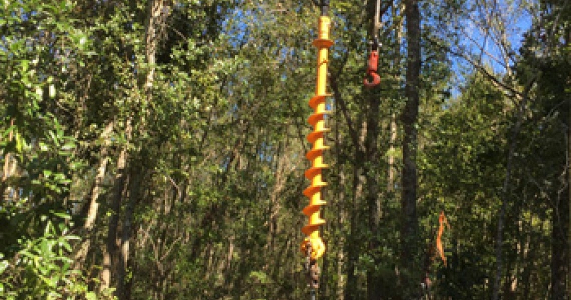 In the woods of Colleton County, lineworkers position the auger of a flexible-track mounted vehicle to drill a power pole hole on Oct. 11. 